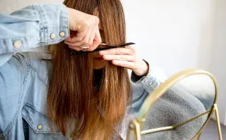 Una mujer cortándose el pelo