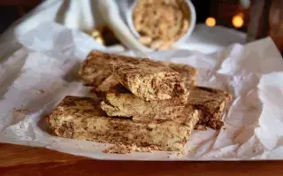 Pilas de trozos de mantecol con chocoalte sobre un plato y papel manteca