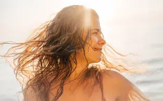 Una mujer con el pelo mojado disfrutando de un día de playa