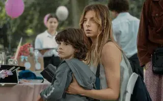 Una mamá sosteniendo a un niño a upa.