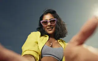 Una mujer con anteojos con una campera en color amarillo