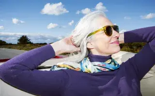 Una mujer con canas posando con su pelo largo