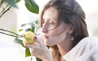mujer oliendo un limón