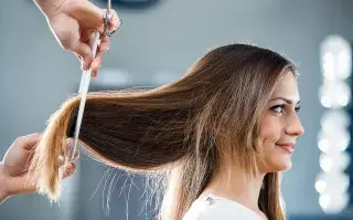 Una mujer en la peluquería cortándose el pelo