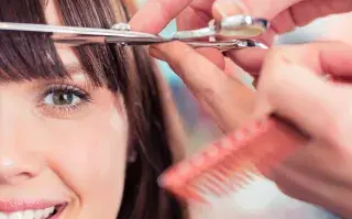 Una mujer cortándose el pelo