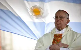 El cardenal argentino Jorge Bergoglio oficia una misa ante la iglesia de San Cayetano, con una bandera argentina detrás, en Buenos Aires, Argentina, el viernes 7 de agosto de 2009. (AP Foto/Natacha Pisarenko, archivo)