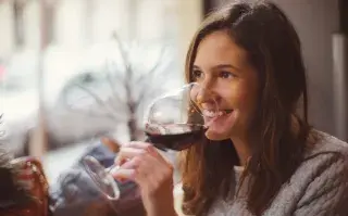 mujer toma vino tinto