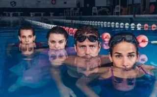 4 actores sumergidos en una pileta de natación.