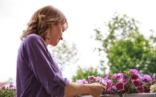 Foto de mujer cuidando sus plantas.