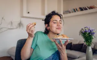 Foto de mujer almorzando.