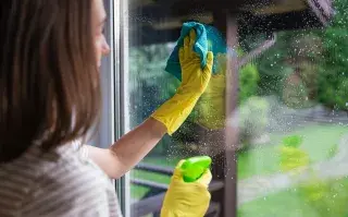 Antes de las lluvias: 5 trucos caseros (con vinagre y bicarbonato) para limpiar vidrios, ventanas y aberturas Foto de mujer limpiando ventanas.