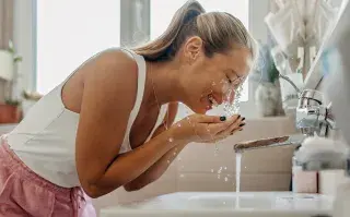 Las mejores formas de hidratar la piel durante días de calor Foto de mujer hidratándose.