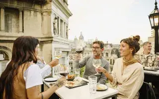 Amigos comiendo y brindando en una terraza