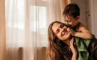 Foto de mujer jugando con su hijo.