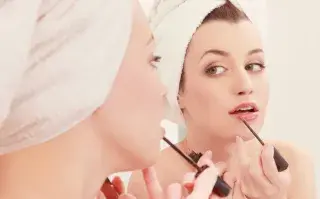 Foto de mujer maquillándose.