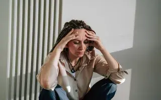 mujer con niebla mental se toma la cabeza