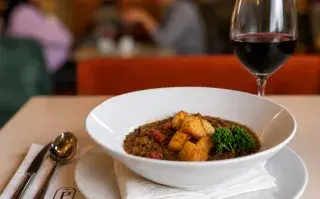 guiso de lentejas y copa de vino