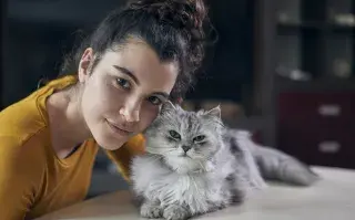 Lo dice una veterinaria: "Si tu gato pestañea lento cuando te mira se siente seguro en tu presencia" chica con su gato reconocer señales de afecto entre ambos