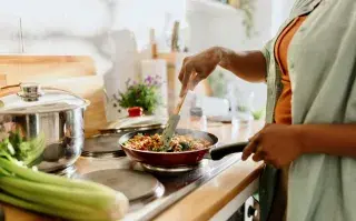 Cenas livianas para el invierno: qué conviene incluir (y qué no) para dormir mejor y sentirte bien una mujer cocina
