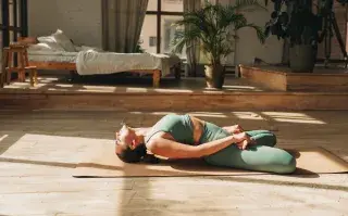 Descansá mejor con esta rutina de yoga restaurativo de 15 minutos Foto de mujer haciendo yoga.