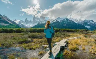No vayas donde va todo el mundo en vacaciones: 5 destinos argentinos para sorprenderte Una mujer vestida con ropa de trekking en un sendero cercano a las montañas.