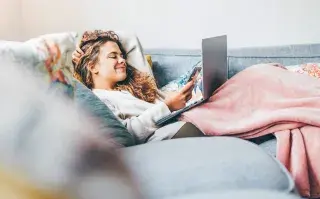 ¿Por qué agosto se siente eterno? La explicación detrás del cansancio de esta altura del año mujer joven en casa con tecnología tapada por el frio