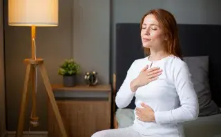 Fertilidad y salud: por qué cuidar tu fertilidad aunque no quieras ser mamá mujer tranquila medita y respira en su cama