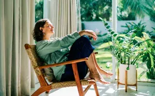 La primavera también llega a casa: 7 cambios simples para renovar los ambientes sin gastar una fortuna Una mujer sentada en u sillón de un living con ventanas y sol