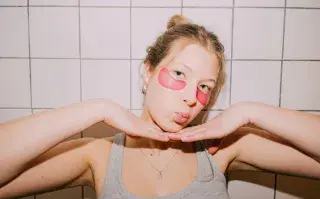 Una joven con parches en los ojos haciendose la rutina de skin care