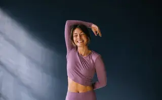 Las mejores prendas para entrenar en invierno: dónde encontrarlas Una mujer haciendo un estiramiento con ropa deportiva
