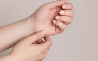 Dos manos con un esmalte de color nude