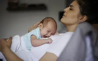 mamá cansada con bebé que llora