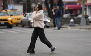 Frío polar en Buenos Aires: 3 looks ideales para vestirte esta semana Una mujer cruzando la calle en nueva york con ropa bien abrigada