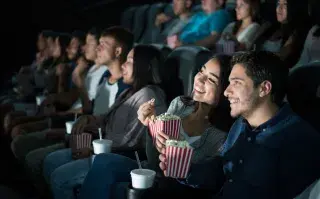 Una pareja mirando una película abrazado en el cine