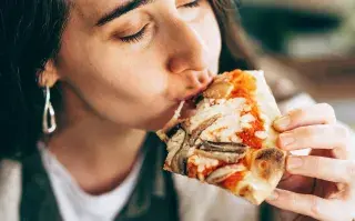 Una mujer comiendo pizza