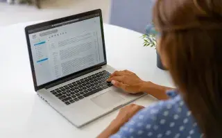 Una mujer escribiendo un correo electronico.