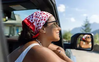 Una mujer en un auto disfrutando del viaje
