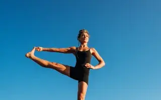 mujer hace equilibrio en una pierna