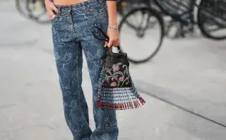 Una mujer con look de street style con unos jeans estampados