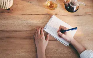 Mano escribiendo en una libreta