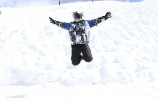 Niño saltando en la nieve