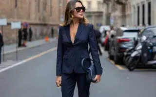 Una mujer con un conjunto sastrero en un tono azul oscuro