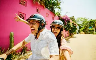 Una pareja viajando en moto sonriendo