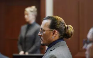Los actores Johnny Depp, al frente, y Amber Heard comparecen en el Tribunal de Circuito del Condado de Fairfax, en Fairfax, Virginia, el jueves 5 de mayo de 2022 (Foto AP/Steve Helber, Pool)