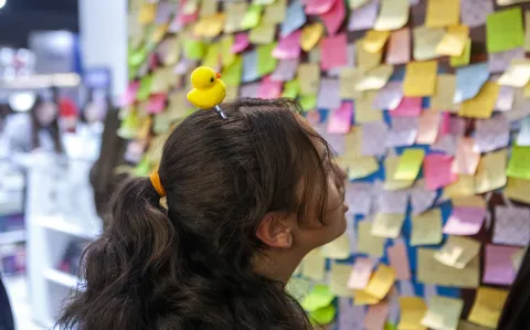 Una chica argentina recorriendo la Feria del Libro con un patito en la cabeza.