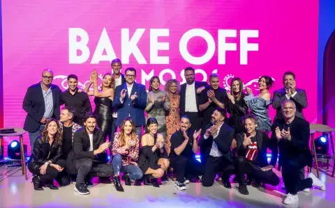 Todo el elenco y jurados de Bake Off posando sobre un escenario.