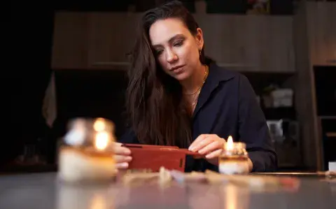 Mujer haciendo un ritual de fin de año con velas e incienso