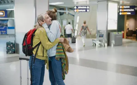 Madre e hija se despiden en el aeropuerto.