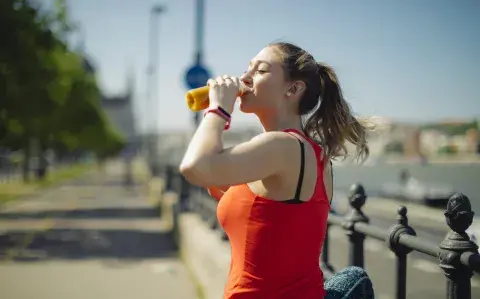 mujer hidratándose después de hacer actividad física