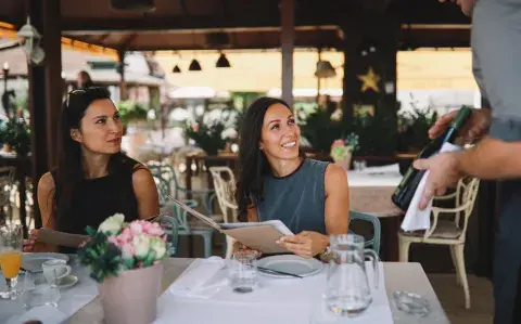 mozo y dos mujres en un restaurante